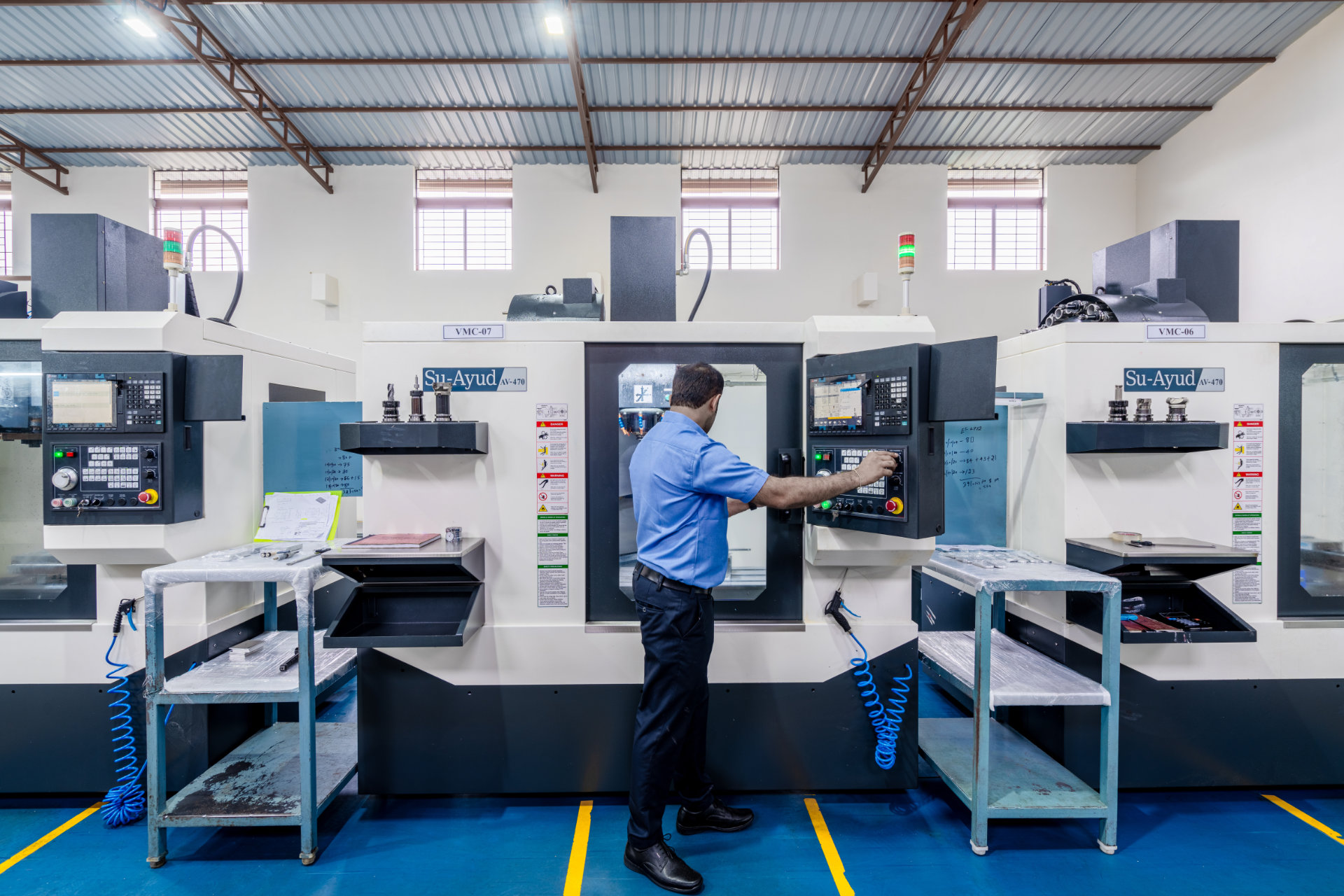 Man operating CNC machinery in workshop